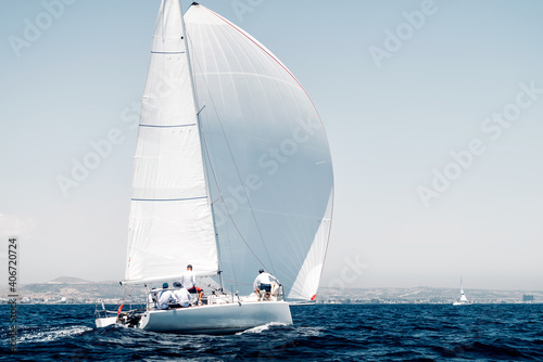 Sport boat with a white sail on regatta, rear view