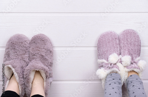 raised up legs of two girls in warm slippers