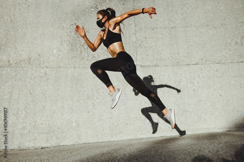 Fitness woman sprinting wearing face mask