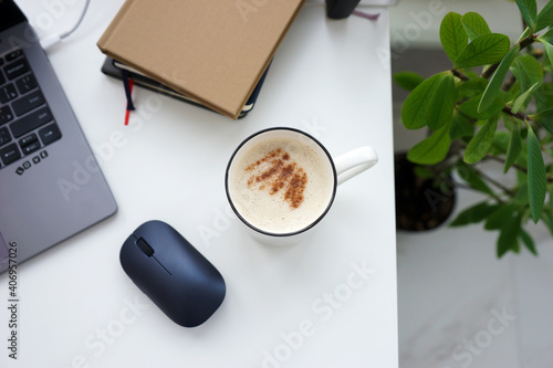 Office desk with laptop and coffee cup at home