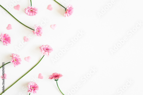 Valentine's Day background. Pink flowers, hearts on white background. Valentines day concept. Flat lay, top view, copy space