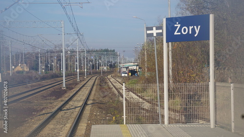 Tory kolejowe przy dworcu kolejowym w Żorach w Polsce. Torowisko biegnie między słupami zasilającej sieci trakcyjnej i sygnalizacyjnymi