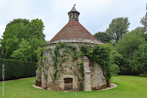 DORCHESTER, DORSET, UK - AUGUST 21ST 2020: A dovecote with ivy growing on it, stands in the ground of an English stately home