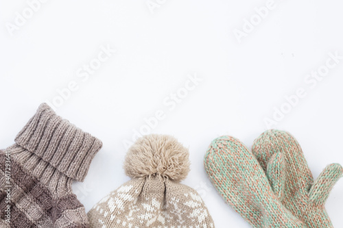 A set of fashionable winter clothes Knitted sweater hat and gloves on white background with copy space