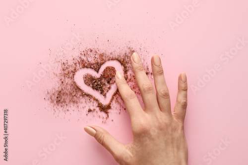 Hand and heart made of powder on color background