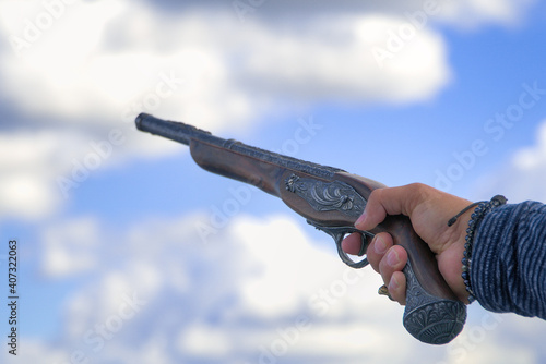 Zabytkowy pistolet skierowany ku niebu.