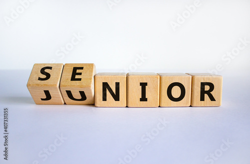 From junior to senior symbol. Turned cubes and changed the word 'junior' to 'senior'. Beautiful white background, copy space. Business and junior or senior concept.