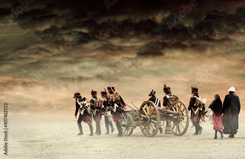 Napoleonic soldiers and women marching and pulling a cannon through plain land, empty countryside with stormy dark red clouds. No recognizable people.