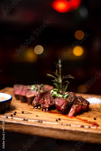 Entrecote Beef Grilled steak meat on wooden cutting boardon with rosemary branch, pepper and salt .