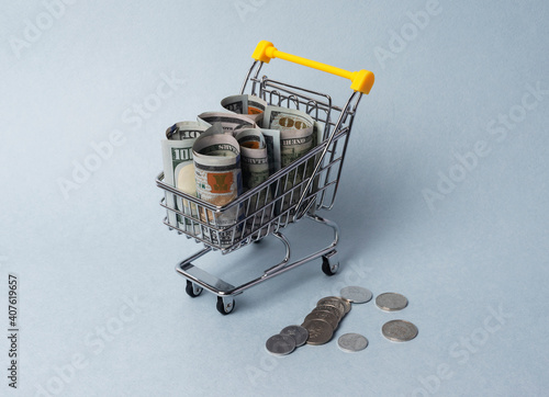 Shopping cart with money. Concept of purchasing power and expenses on food