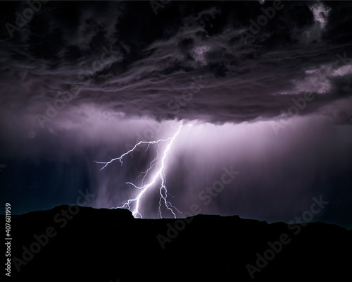 Powerful lightning storm in the American Southwest. One sees the silhouette of the hills on bottom, the lightning, and the cumulonimbus clouds. 