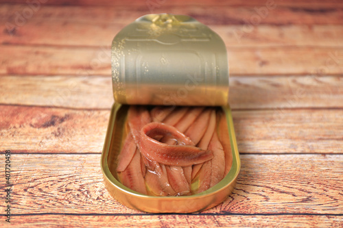 Open can of Cantabrian anchovies (Santoña anchovies) on wooden table with blur and blank space