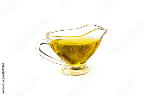 Natural vegetable oil in a small glass cup, isolated on a white background.
