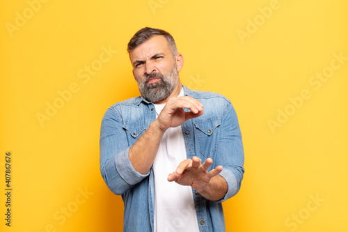 adult handsome man feeling disgusted and nauseous, backing away from something nasty, smelly or stinky, saying yuck