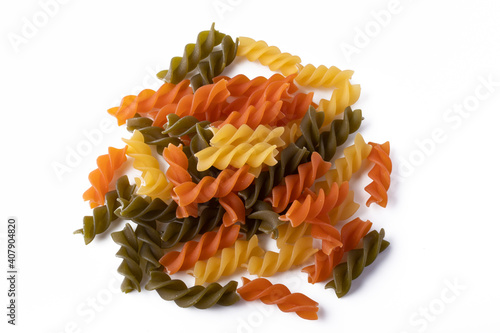 Multicolored spiral macaroni on white background Heaps of homemade pasta fusilli