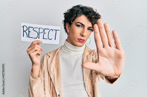 Young man wearing woman make up and woman clothes holding respect banner with open hand doing stop sign with serious and confident expression, defense gesture