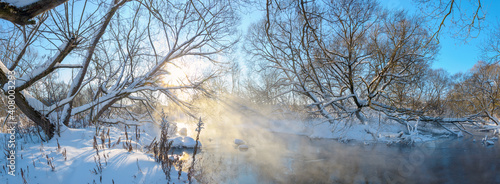 Frosty winter landscape with forest river during sunny january morning