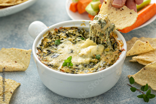 Artichoke spinach dip in a baking dish with a cheese pull