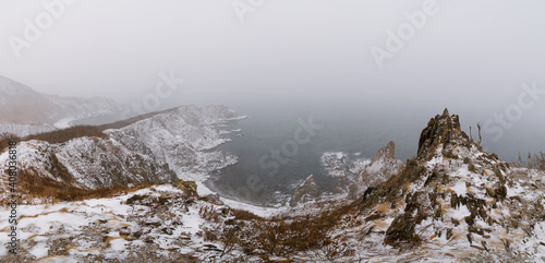 Snow storm over sharp sea cliffs 