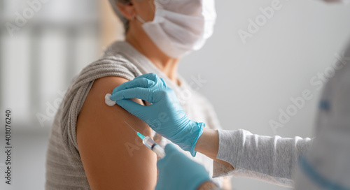 Doctor giving a senior woman vaccination