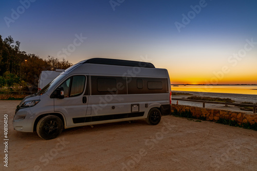 nightfall with a colorful sky over wetlands and canals nature landscape and a camper van in the foreground