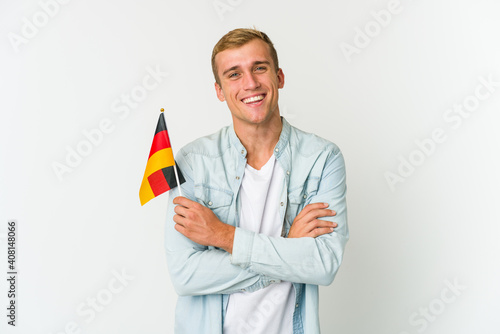 Young caucasian man holding a german flag isolated on white background