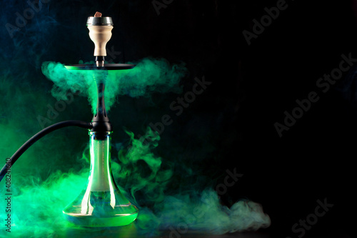 Smoking hookah on black background with color fog