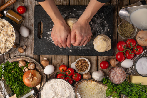 Chef kneading dough for bread, pizza, pasta with ingredients, top view, food preparation process. Delicious food, cooking and recipe book