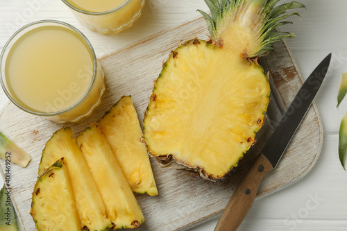 Concept of breakfast with pineapple and glasses with juice on wooden table, top view