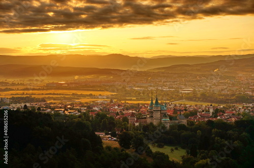 Beautiful aerial view on Bojnice castle and town of Bojnice in Slovakia in a warm yellow light at sunrise, with interesting black clouds in the sky