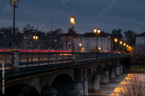 Light trails of the car in the evening on the Parma bridge during sunset