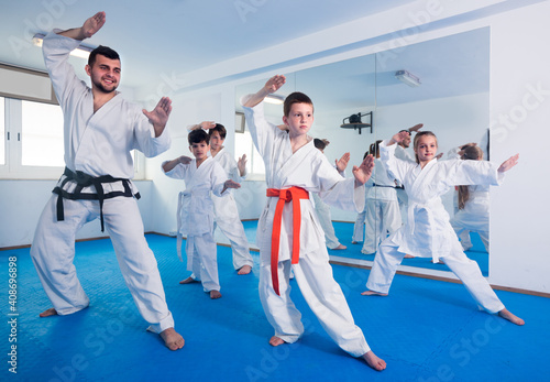 Coach is training children in karate class.