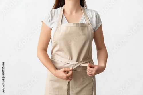 Female waiter wearing apron on white background