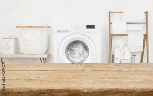 Wooden table in front of washing machine loaded with laundry