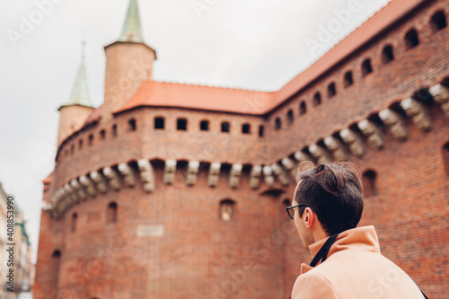 Tourist looking at Barbikan gate in Krakow city, Poland. Barbakan museum. Man enjoys sightseeing