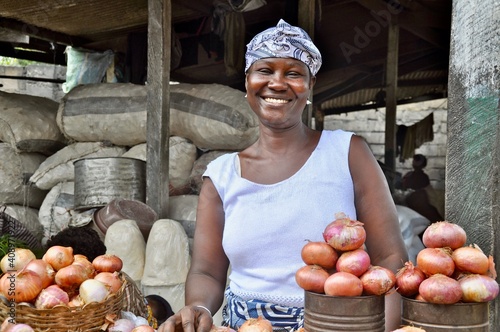 Portrait Of A Smiling Woman Selling Onions On Makola Market In Accra, Ghana