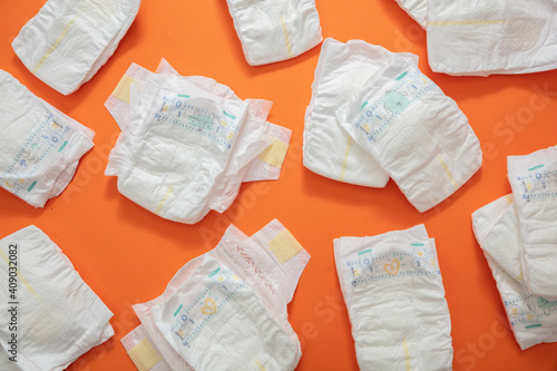 Baby diapers collection on orange color background.