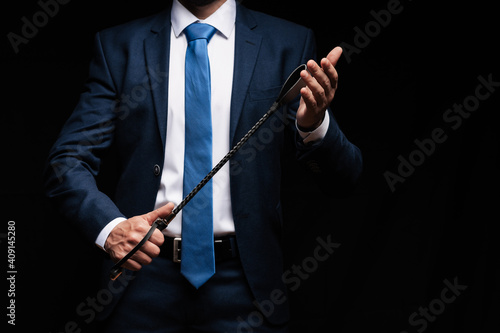 male dominant holds a leather whip Flogger for hard BDSM sex