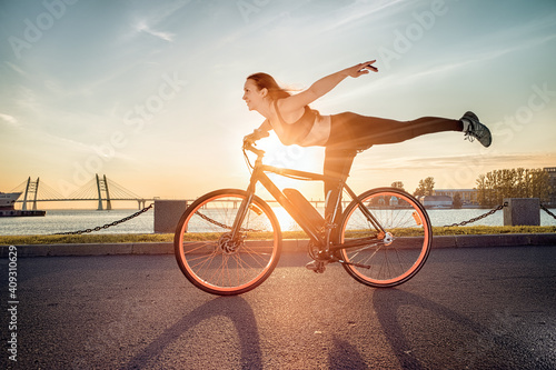 Athletic girl performing acrobatic riding on electric bike