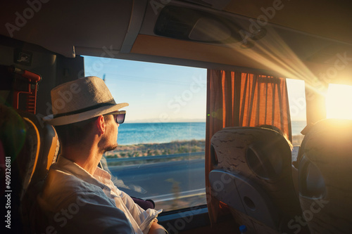 A man is traveling and looking through the bus window during the covid pandemic