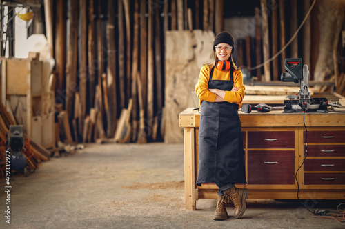 Positive woman working in joinery workshop