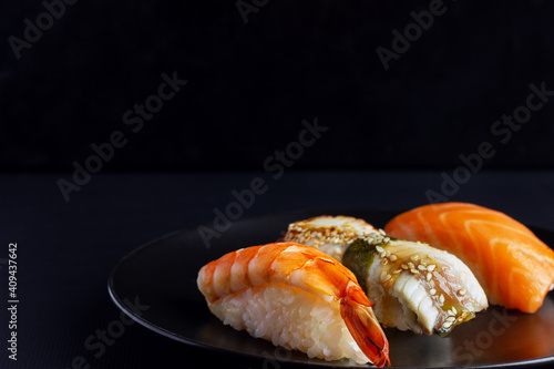 Sushi set on black background, traditional Japanese food.