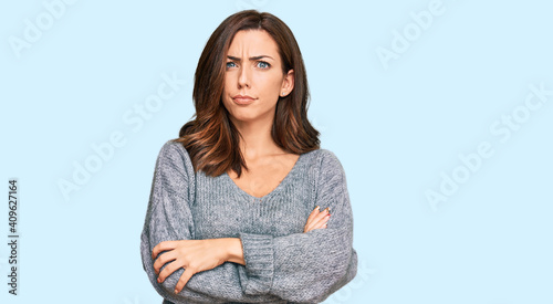 Young brunette woman wearing casual winter sweater skeptic and nervous, disapproving expression on face with crossed arms. negative person.