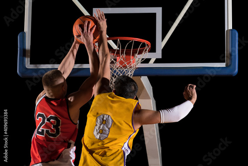 Two basketball players in action. Blocked shot