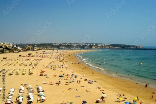 View from the cliffs to people on the beach Praia da Rocha at Portimao. Algarve beach during the summer vacation, Portugal, Europe.