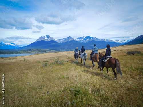 Four people enyojing to horse riding in Patagonia, Torres del Paine national park, near the lago Sophia, Puerto Natales. Incredible landscape.