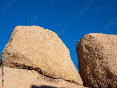 Sun shine on boulders with blue sky and jetstream