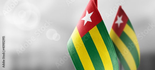 Small national flags of the Togo on a light blurry background