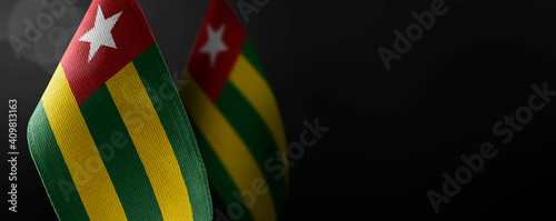 Small national flags of the Togo on a dark background