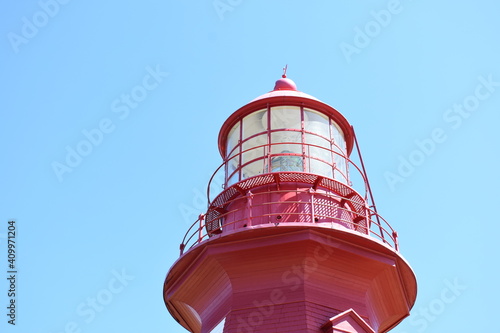 top of red and white lighthouse in the blue sky
